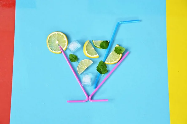 Concept for summer drink - Straws make up the glass in the lemons, limes, mint and ice floats against a colorful background - Abstract illustration of a summery refreshmentwith space for text