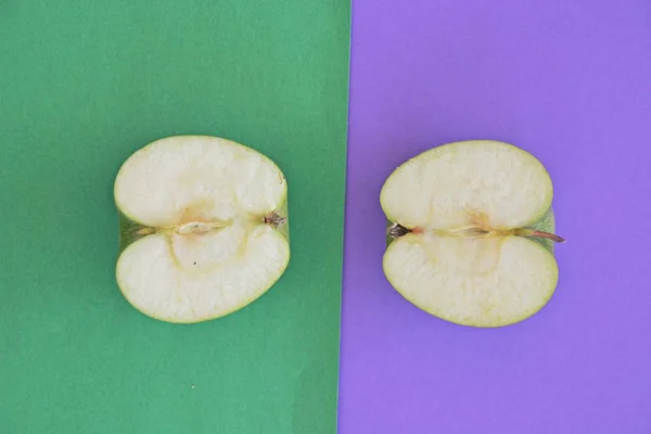 两个不同颜色背景上的苹果的两半 — 图库照片
