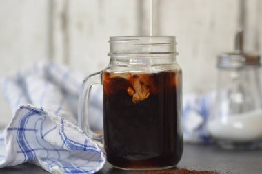 bir buzlu kahve içine süt dökün