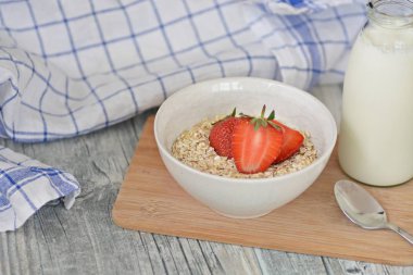 Sabahları sağlıklı bir kahvaltı olarak bir kase çilek ile yulaf ezmesi 