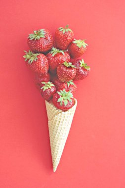 Renkli bir arka plan üzerinde çilek ile dondurma konisi