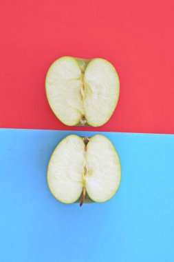 İki farklı renkli arka plan üzerinde bir elma iki yarısı