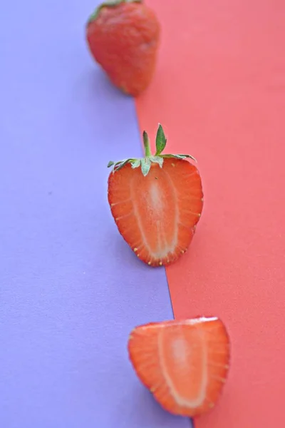 Strawberry close-up on two colored background, fruits summer