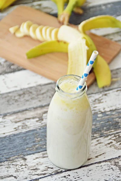 banana milkshake with straw on wooden background