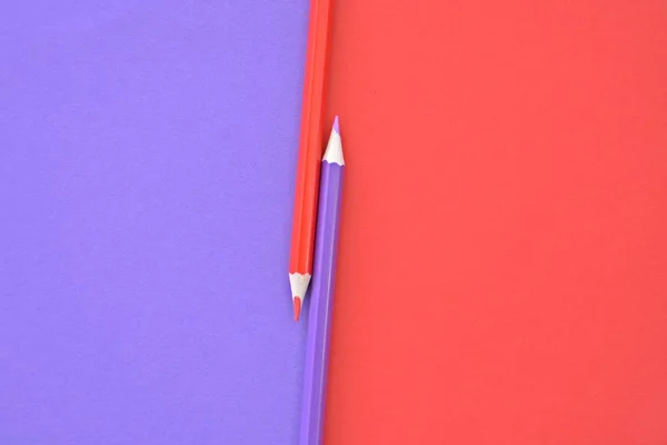 Two colored pencils split a picture in half in two different colors