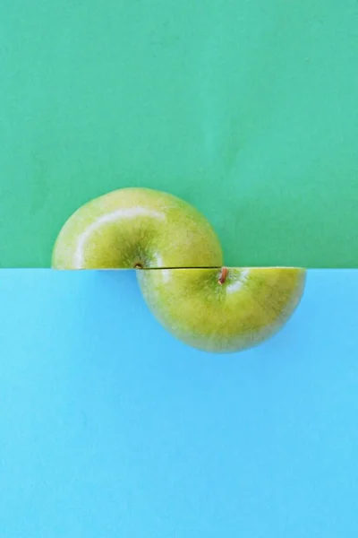 Two halves of an apple on two different colored backgrounds