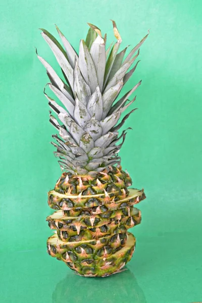 slices of a pineapple make up a whole pineapple in front of a solid background with space for text or objects