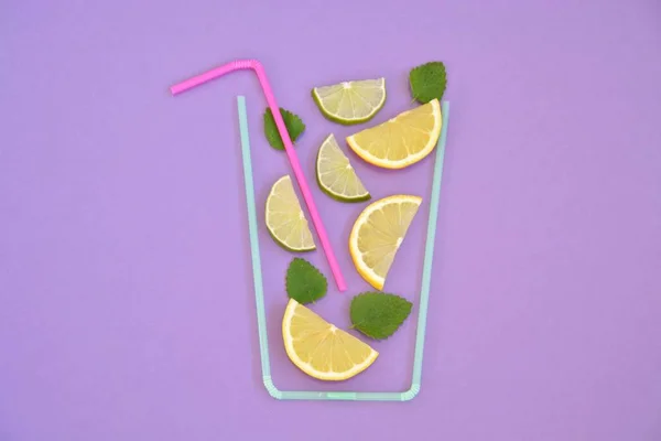 Creative layout strawberry lemonade ingredients - lemon, citrus, ice falling in glass made with cocktail straws on colorful background. Summer drinks. Minimal food concept. Selective focus.