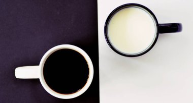 Yarım siyah ve yarım beyaz arka plan önünde iki bardak, bir fincan kahve içerir, diğer süt ve her ikisi de bir kontrast creat, kahve fincanları ile yin ve yang için kavram