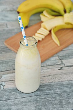 ahşap arka planda saman ile muz milkshake