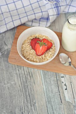 Sabahları sağlıklı bir kahvaltı olarak bir kase çilek ile yulaf ezmesi 