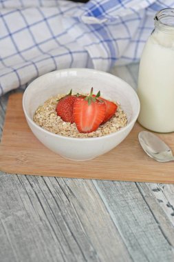 Sabahları sağlıklı bir kahvaltı olarak bir kase çilek ile yulaf ezmesi 