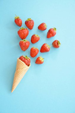 Renkli bir arka plan üzerinde çilek ile dondurma konisi