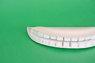 Kollu bir arka planda şeker küpleri dışında dişler