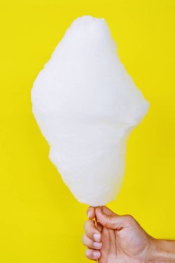 Close-up - adam elinde tek renkli arka plan önünde bir Alman kermis pamuk şeker tutar