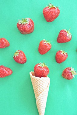 Renkli bir arka plan üzerinde çilek ile dondurma konisi