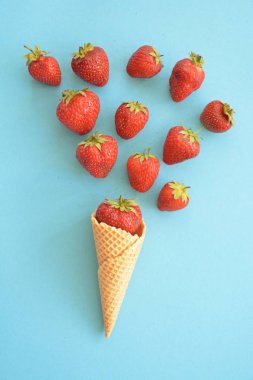 Renkli bir arka plan üzerinde çilek ile dondurma konisi