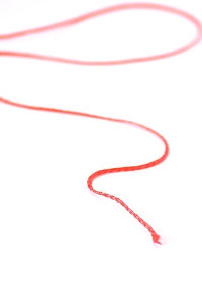 Немецкая фраза "нить рассказа" абстрактно изображена как картинка с красной нитью перед белым фоном - представляет внутреннюю последовательность истории
