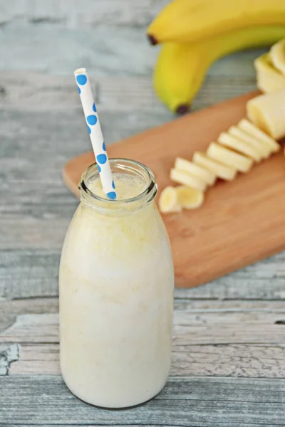 banana milkshake with straw on wooden background