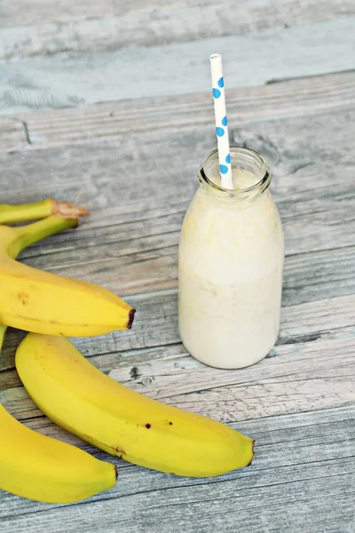 banana milkshake with straw on wooden background