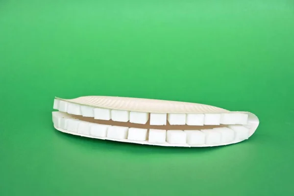 Kollu Bir Arka Planda Şeker Küpleri Dışında Dişler — Stok fotoğraf