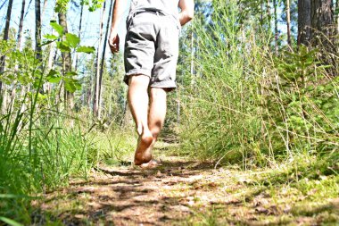 Ayaklarda yakın çekim - ormanda çakıl bir yol boyunca yürür ve yazlık sıcaklıklarda doğada rahatlatır