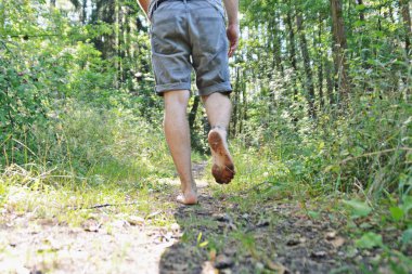 Ayaklarda yakın çekim - ormanda çakıl bir yol boyunca yürür ve yazlık sıcaklıklarda doğada rahatlatır