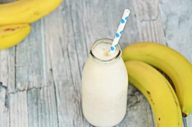 ahşap arka planda saman ile muz milkshake