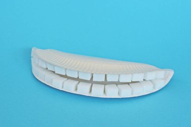 Kollu bir arka planda şeker küpleri dışında dişler