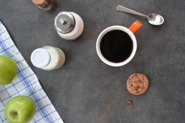 Elma, süt, şeker ve bisküvi ile bir masada bir portakal fincan Kahve 