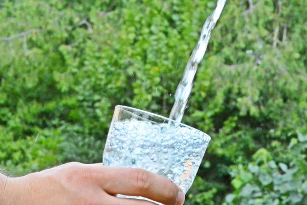 Agua Dulce Limpia Fluye Vaso Frente Fondo Veraniego Verde Sostenido — Foto de Stock