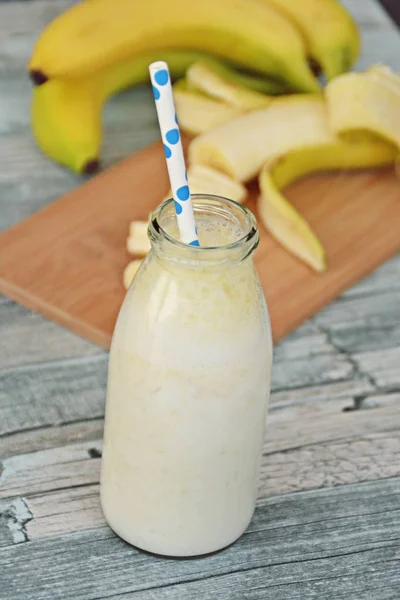 banana milkshake with straw on wooden background