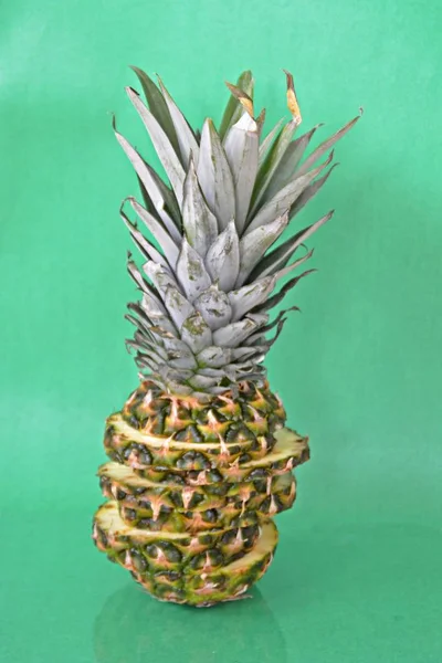 slices of a pineapple make up a whole pineapple in front of a solid background with space for text or objects