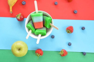 Bir ferahlık olarak yaz için mükemmel bir ahşap arka planda çilek, yaban mersini, elma ve muz ile ev yapımı dondurma 