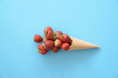 Renkli bir arka plan üzerinde çilek ile dondurma konisi