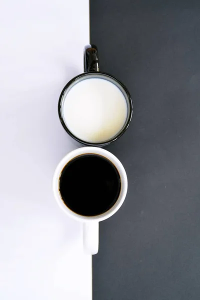 Две Чашки Фоне Получёрного Полубелого Фона Одна Чашка Содержит Кофе — стоковое фото