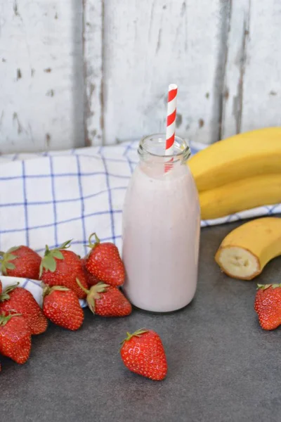 Homemade milk shake with strawberries and bananas as a perfect refreshment in summer