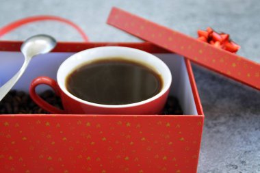 Bir fincan kahve dolu içinde kahve çekirdekleri ile bir Noel hediye kutusunda - kahve noel için bir tedavi ve hediye olarak güzel paketlenmiş 
