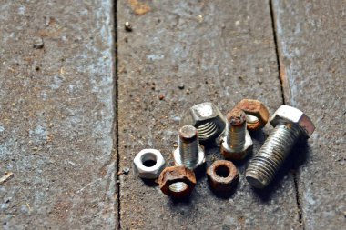 Çeşitli vidalar arkasında pozlama ile ahşap bir tezgah üzerinde yatıyor 