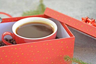 Bir fincan kahve dolu içinde kahve çekirdekleri ile bir Noel hediye kutusunda - kahve noel için bir tedavi ve hediye olarak güzel paketlenmiş 