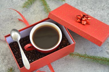 Bir fincan kahve dolu içinde kahve çekirdekleri ile bir Noel hediye kutusunda - kahve noel için bir tedavi ve hediye olarak güzel paketlenmiş 