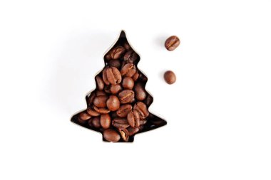 Metin veya diğer unsurlar için yer ile beyaz bir arka plan önünde kahve çekirdekleri ile dolu çerezleri için bir çerez kesici - noel şekli ve kahve çekirdekleri ile kavram 