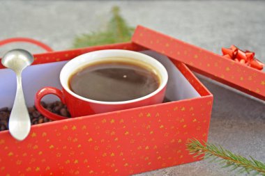 Bir fincan kahve dolu içinde kahve çekirdekleri ile bir Noel hediye kutusunda - kahve noel için bir tedavi ve hediye olarak güzel paketlenmiş 
