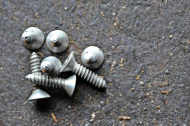 Çeşitli vidalar arkasında pozlama ile ahşap bir tezgah üzerinde yatıyor 