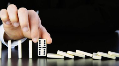 Domino bir başka mükemmel işleyen zincir reaksiyonu bir rahatsızlık faktörü inceleyerek genç bir işadamı bir elin yakın çekim-liderlik kararlarının karmaşıklığı sembolik 
