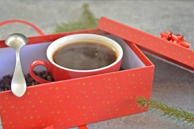 Bir fincan kahve dolu içinde kahve çekirdekleri ile bir Noel hediye kutusunda - kahve noel için bir tedavi ve hediye olarak güzel paketlenmiş 