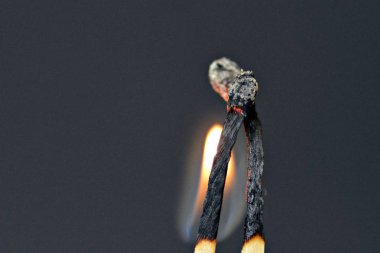 Siyah bir arka plan karşı iki yanmış maçlar bir çift sarılarak ve birbirlerine samimi olmak-kavramı ateşli aşk sembolize