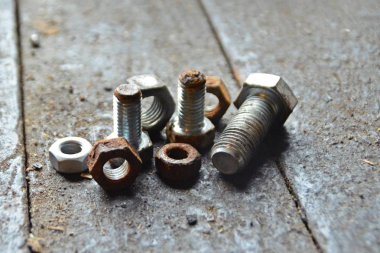 Çeşitli vidalar arkasında pozlama ile ahşap bir tezgah üzerinde yatıyor 