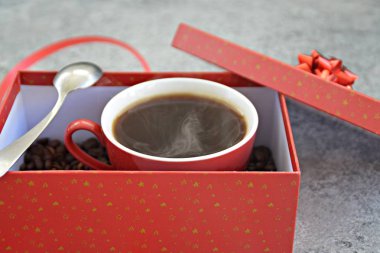 Bir fincan kahve dolu içinde kahve çekirdekleri ile bir Noel hediye kutusunda - kahve noel için bir tedavi ve hediye olarak güzel paketlenmiş 