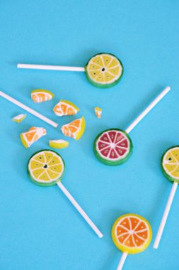 Renkli bir arka planda kireç ve limon veya karpuz gibi meyve görünümü ile lezzetli tatlı lolipop